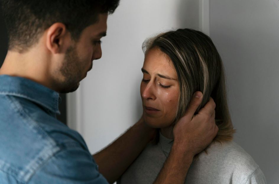 A man comforts a crying woman, representing the importance of seeking professional help for mental health from an Anthem Insurance Psychiatrist in Sugar Land