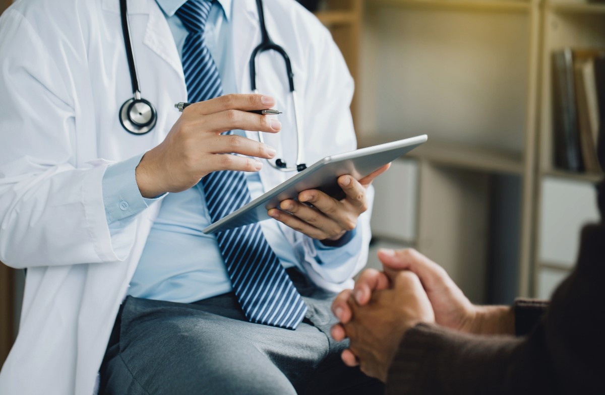 Psychiatrist in white coat with stethoscope and tablet consults patient, reflecting Anthem Insurance psychiatric services in Sugar Land.