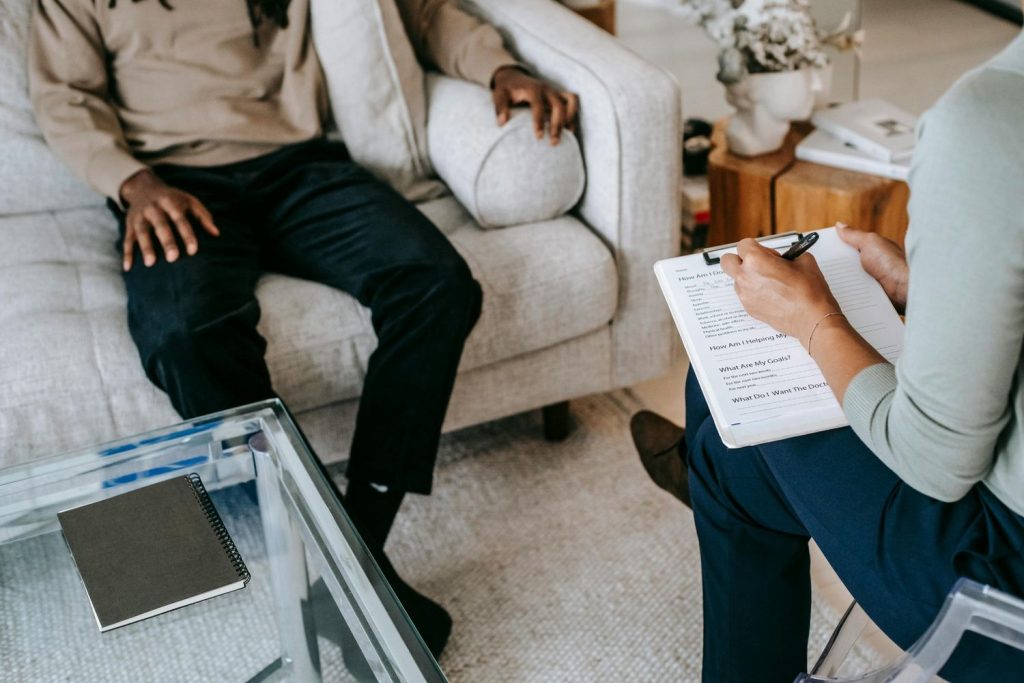 Patient practicing breathing exercises during anxiety treatment with therapist in Sugar Land, in a serene clinical room with soft lighting.