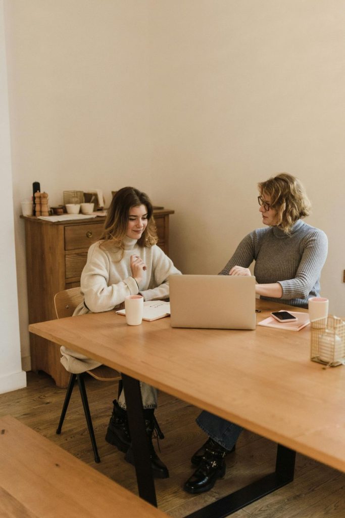 Therapist discussing bipolar treatment with patient in Sugar Land, working together at a desk with a laptop in a cozy office.