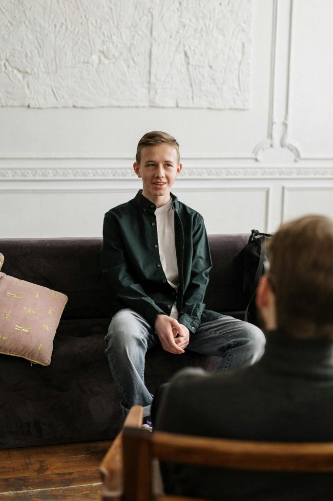 Patient receiving bipolar treatment counseling in Sugar Land, sitting on a couch with a therapist in a warm, supportive setting.