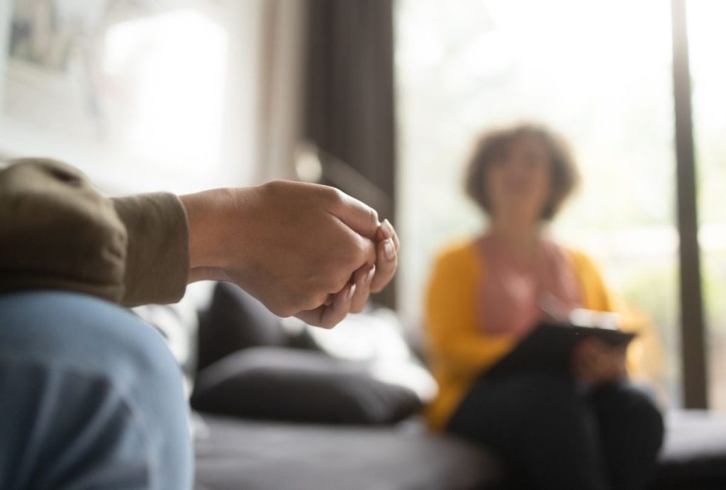 Close-up of teen’s clasped hands during counseling session focused on adolescent depression help in Sugar Land.