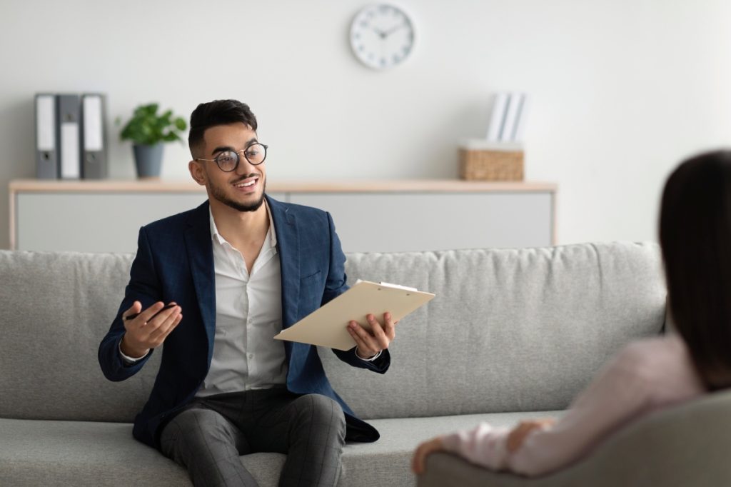 Anxiety Treatment Sugar Land counseling: therapist with clipboard in modern office, supportive one-on-one consultation