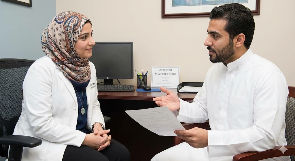 A patient discusses his plan with a female psychiatrist, with a sign nearby for a psychiatrist in sugar land with insurance.