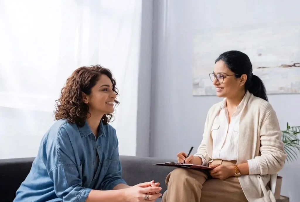 Happy young woman with curly hair on a couch, consulting a female therapist for anxiety treatment sugar land.