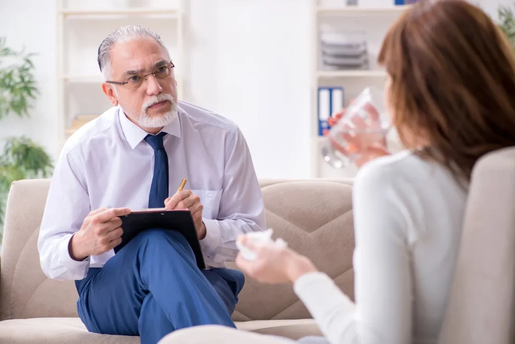 Senior specialist at anxiety doctors Sugar Land taking notes while listening to a patient in a supportive environment.