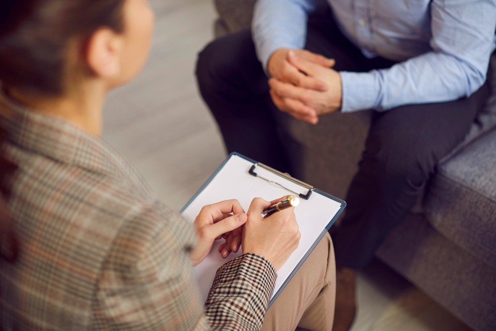 A specialized Sleep Disorder Psychiatrist in Sugar Land takes notes during a comprehensive patient evaluation.